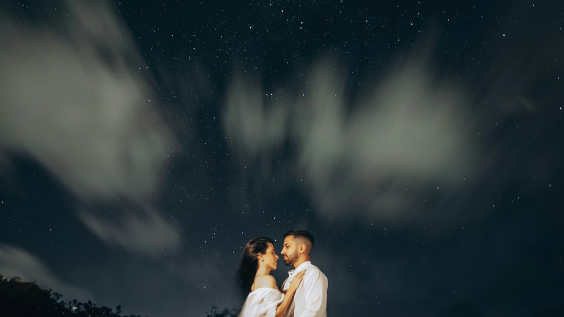 Yıldızlı gece gökyüzü altında duran bir çift
